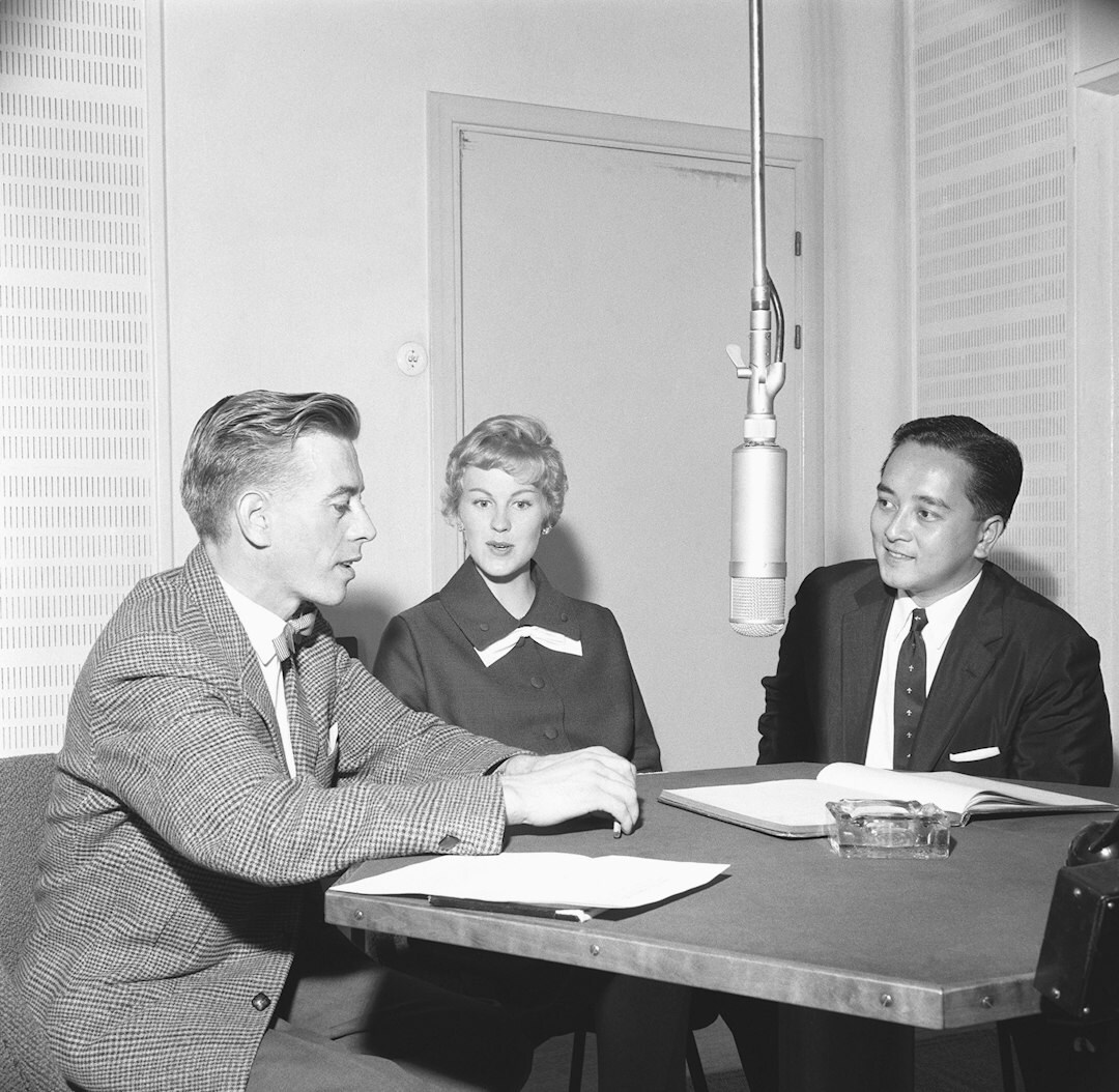Diverse editorial team gathered around a table discussing work